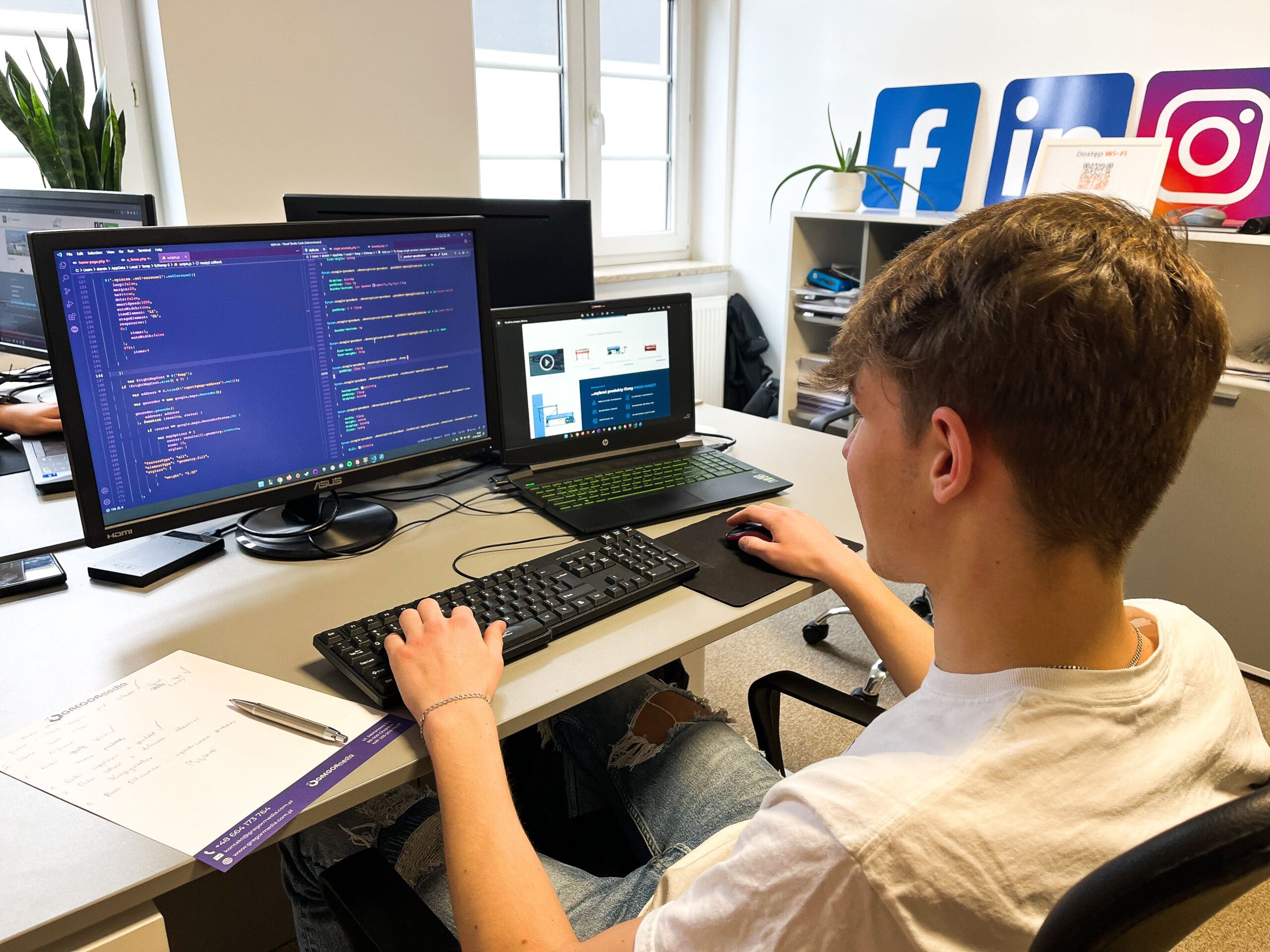 Młody mężczyzna przy biurku pracujący nad strategią marketingową przy użyciu komputera.