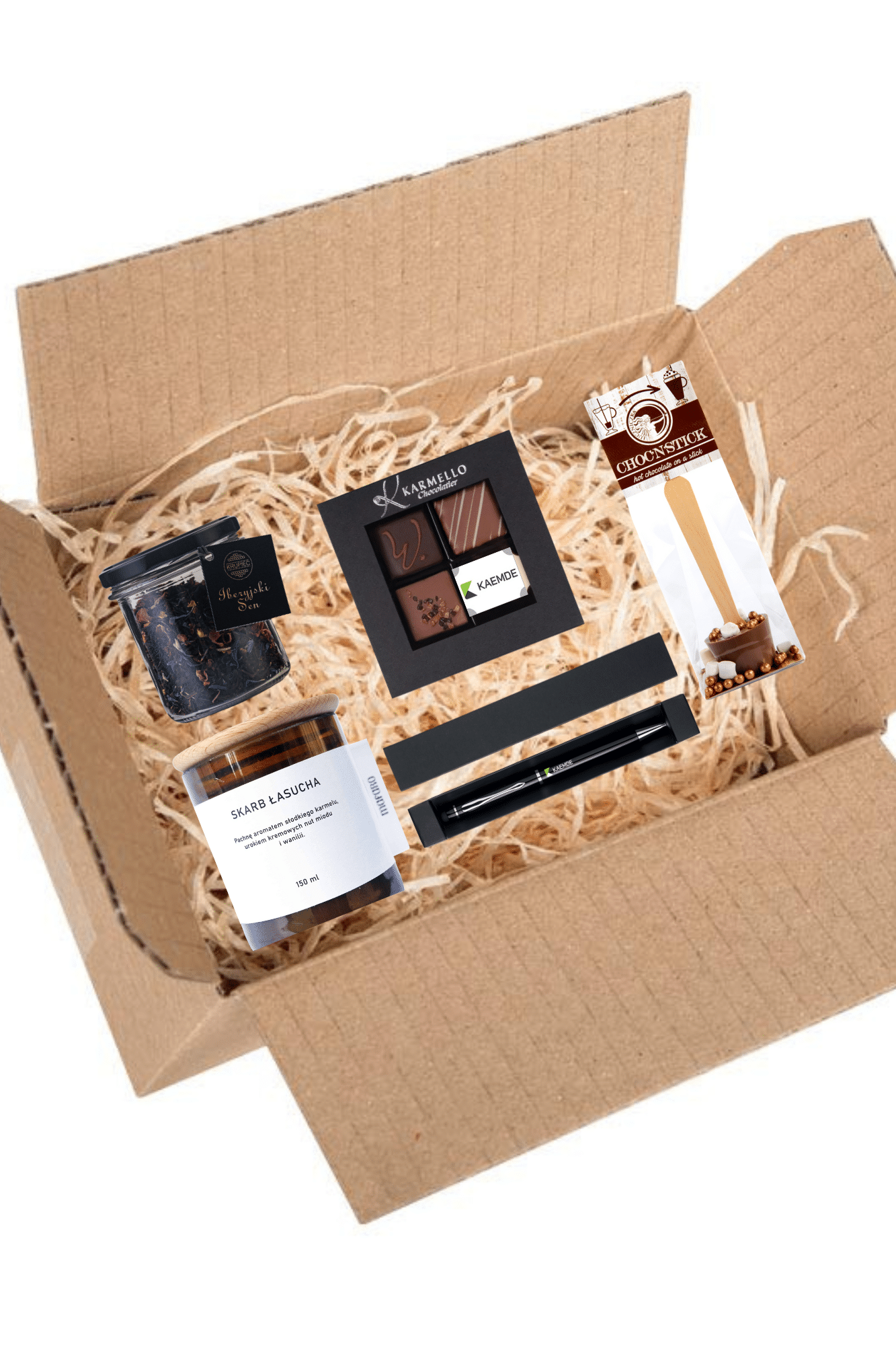 Otwarte kartonowe pudełko upominkowe wypełnione asortymentem tabliczek czekolady i małym słoiczkiem, ustawione na łóżku z dekoracyjnej słomy.
